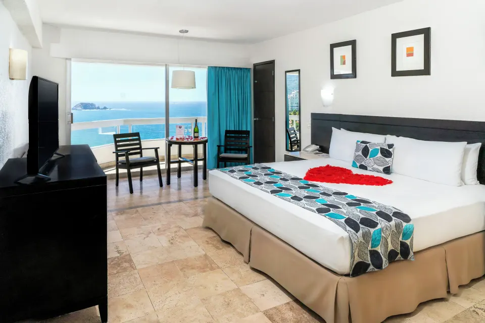Ocean View room with king bed, seating area, and balcony sea view at Krystal Ixtapa.