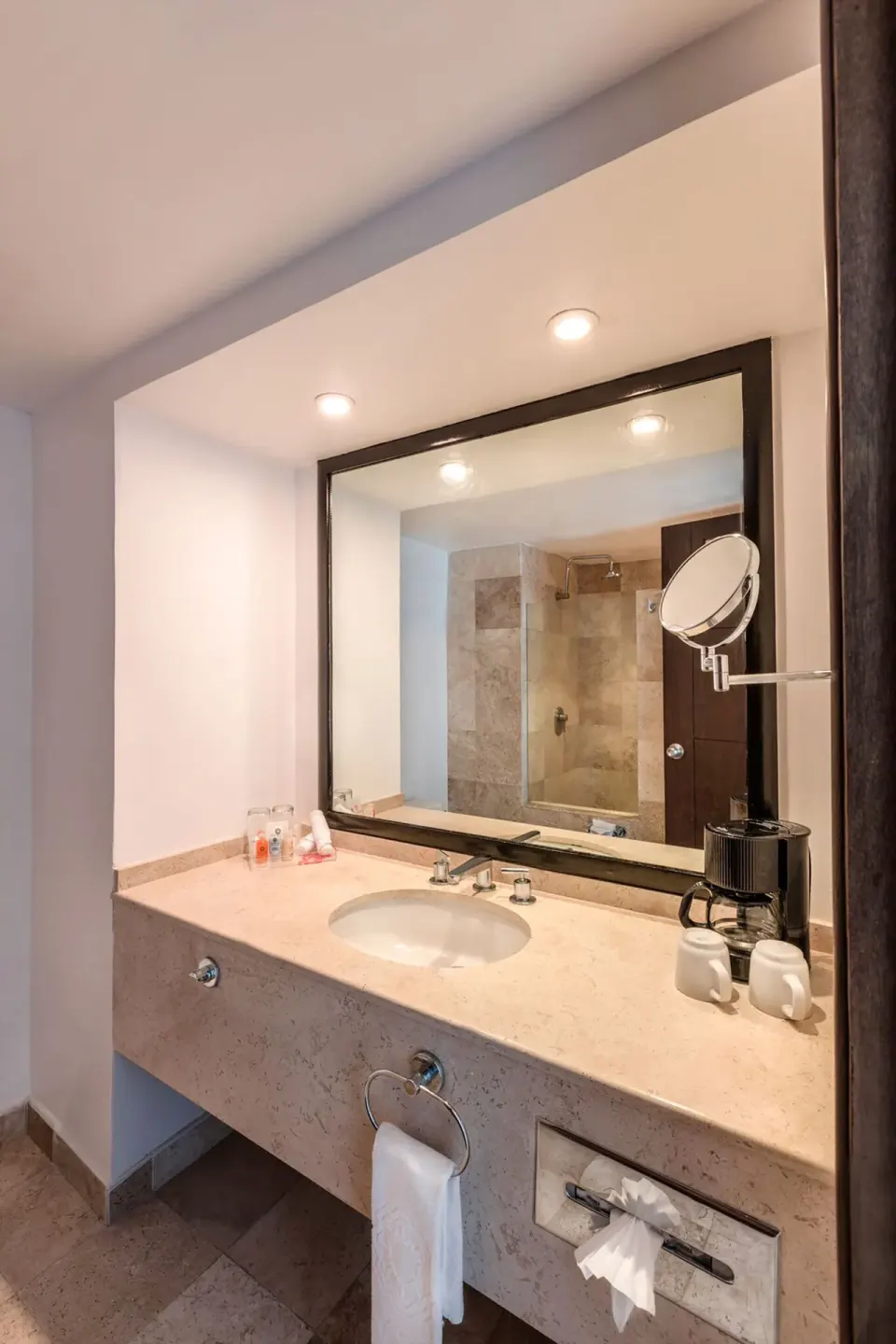 Standard room bathroom vanity with sink, mirror and coffee setup at Krystal Ixtapa.