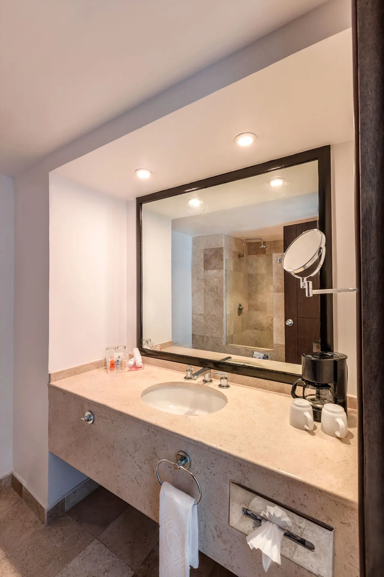 Standard room bathroom vanity with sink, mirror and coffee setup at Krystal Ixtapa.