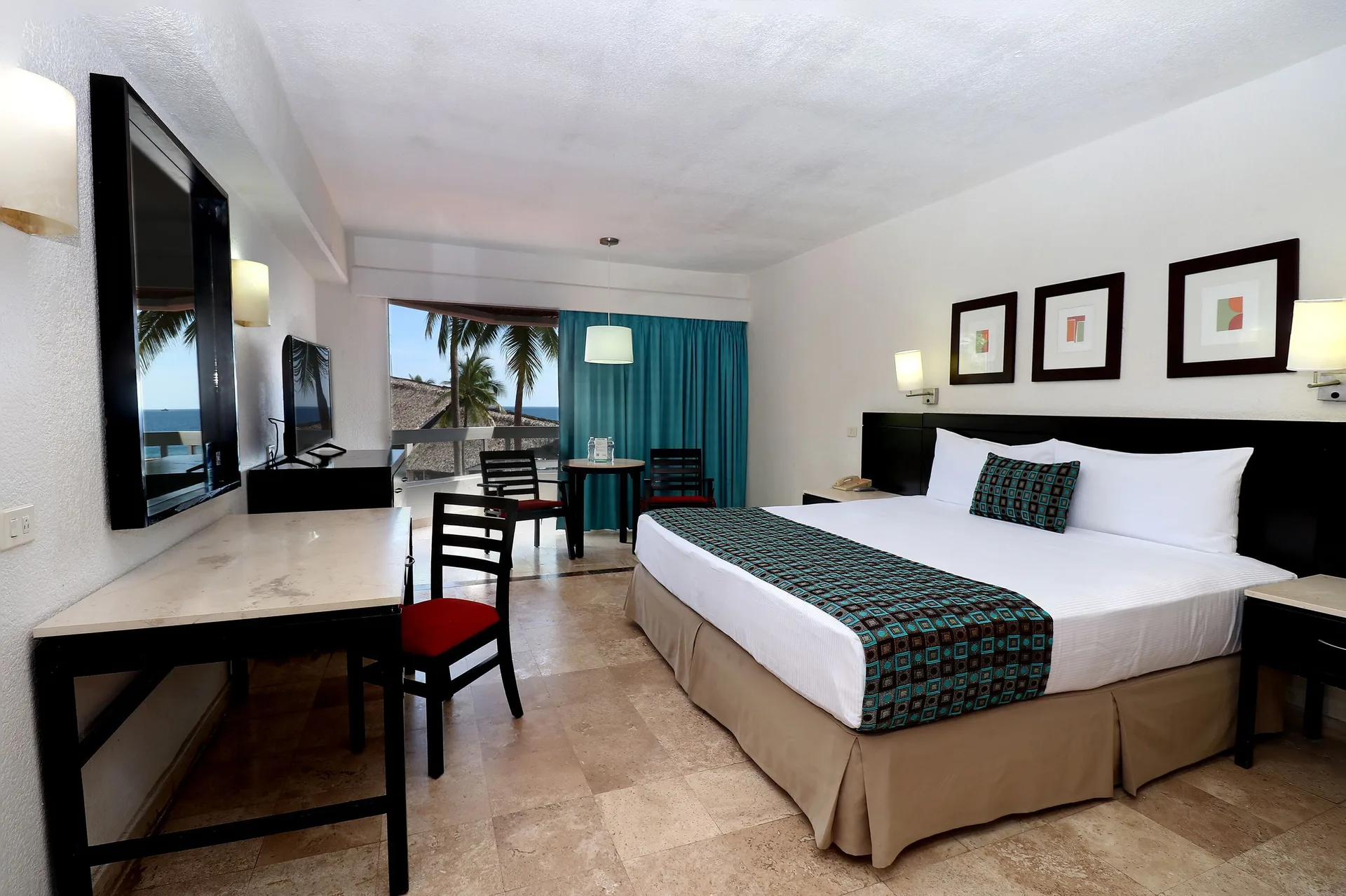 Standard room with king bed, desk, balcony and ocean glimpse at Krystal Ixtapa.