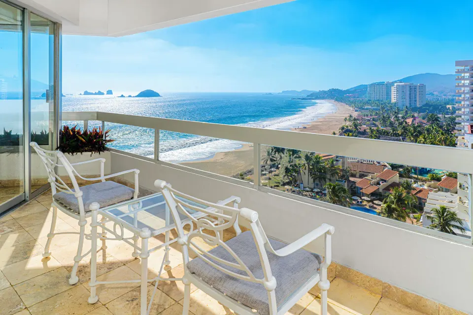 Superior Sea View balcony with chairs and coastline view at Krystal Ixtapa.