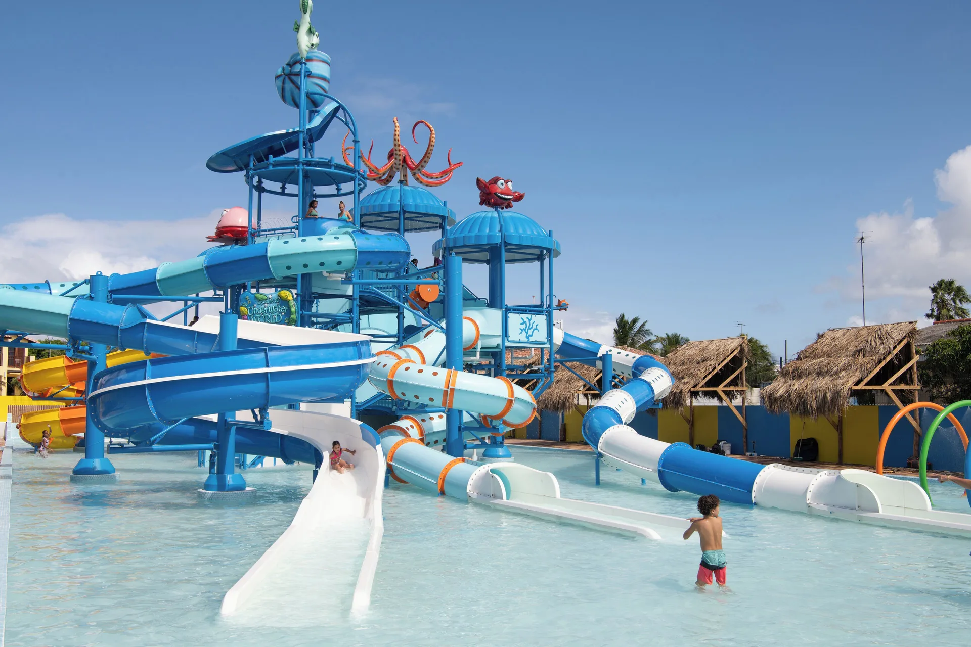 Blue water play structure with tube slides at Kunuku Resort Curacao.