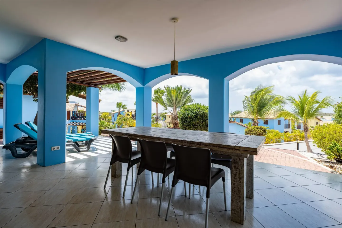 Covered terrace with dining table and lounge chairs at Kunuku Resort Curacao.