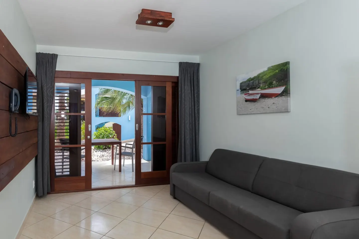 Guest room sitting area with sofa and patio doors at Kunuku Resort Curacao.