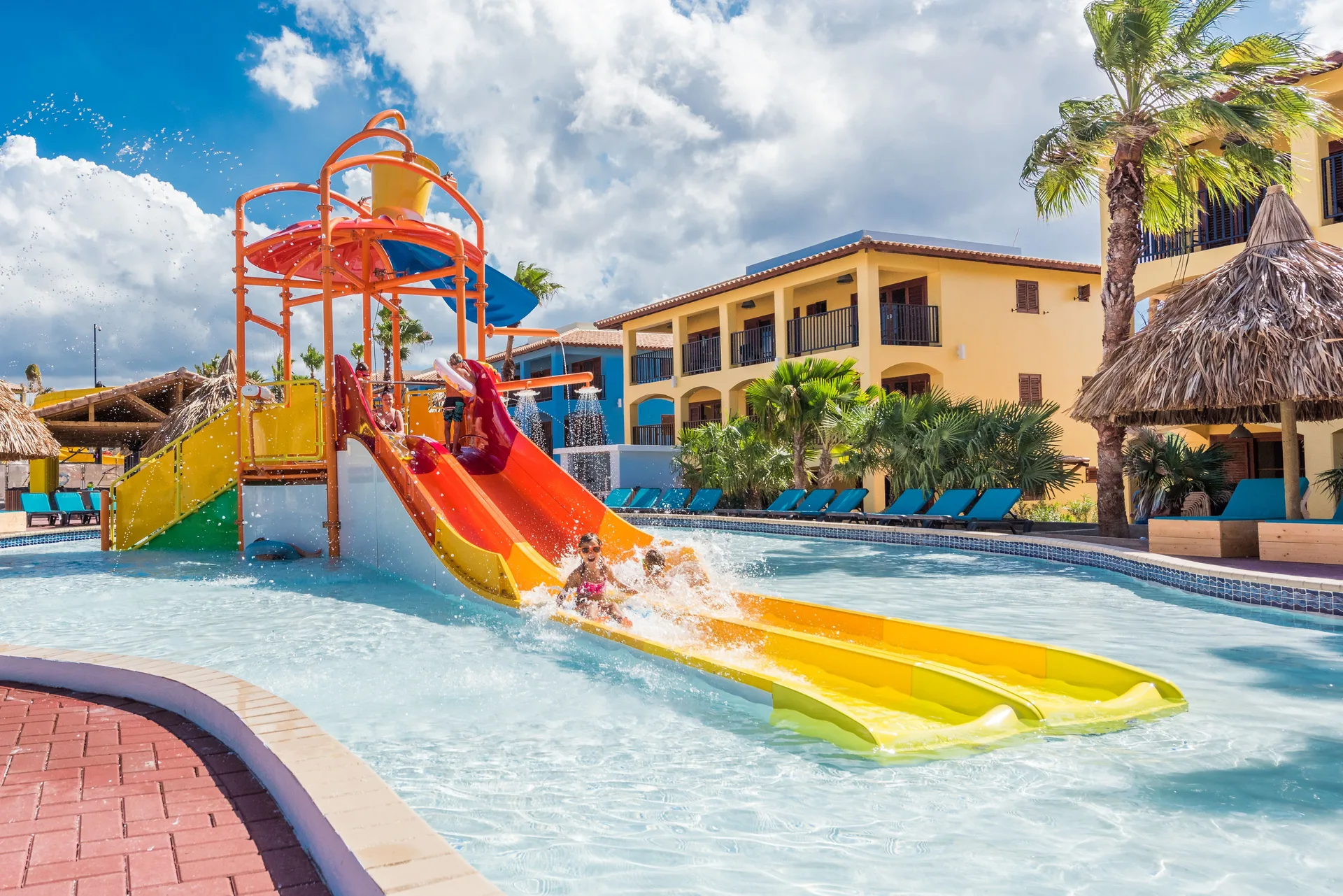 Children splash down twin slides in the kids pool at Kunuku Resort Curacao.