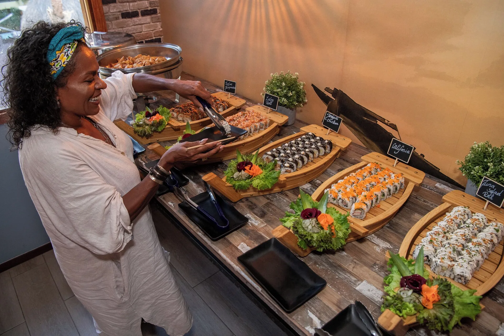 Guest serving sushi rolls from wooden trays at Kunuku Resort Curacao.