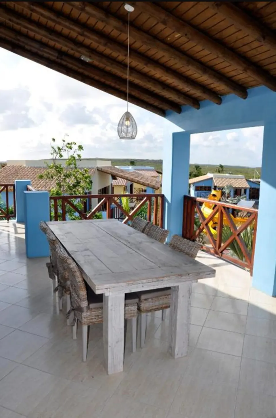 Covered terrace with dining table and resort views at Kunuku Resort Curacao.