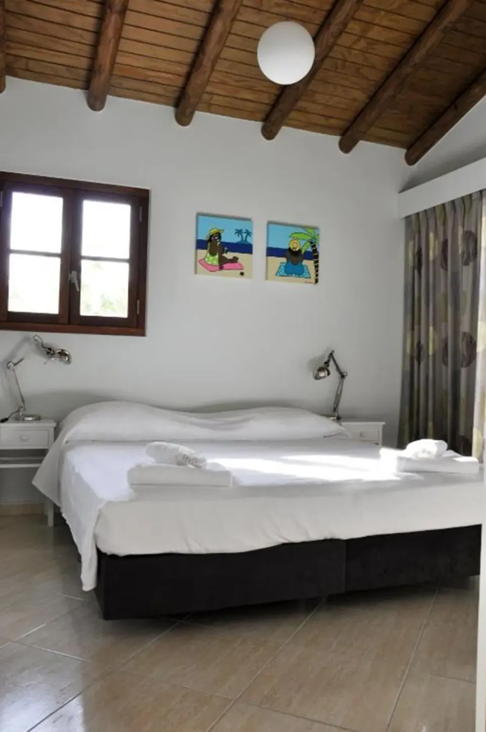 Bedroom with a double bed and wood-beam ceiling in a 3-bedroom apartment at Kunuku Resort Curacao.
