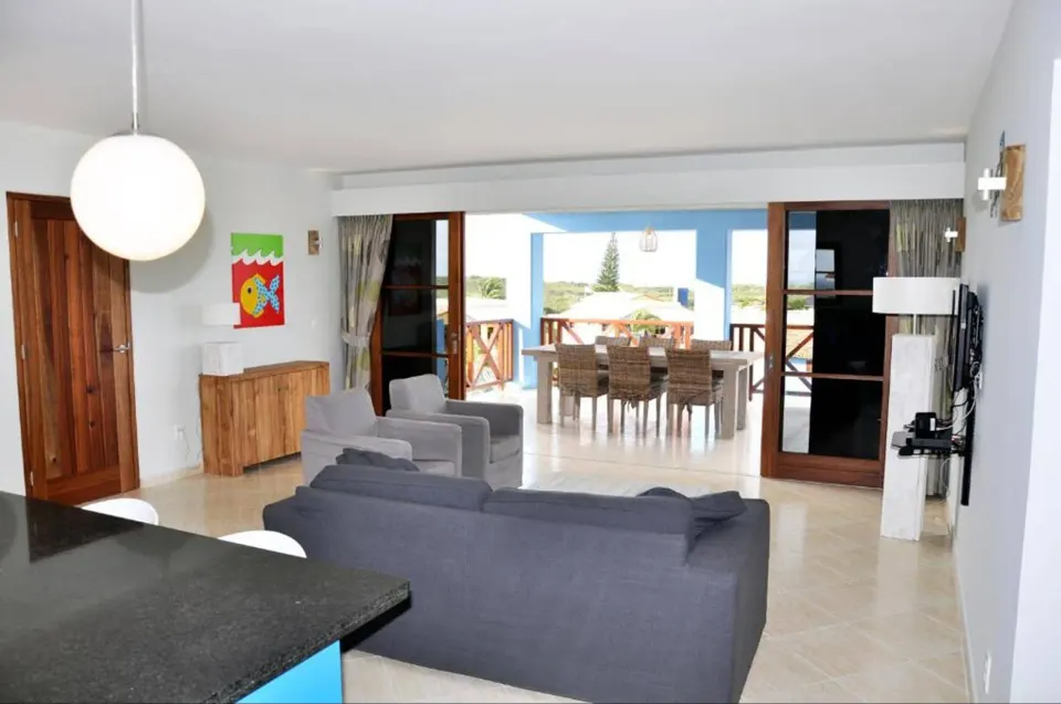 Apartment living area opening to a covered terrace at Kunuku Resort Curacao.