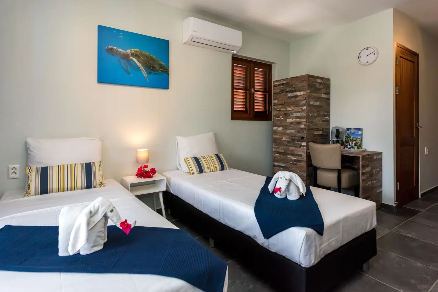 Family Quadruple Room twin beds with blue throws at Kunuku Resort Curacao.
