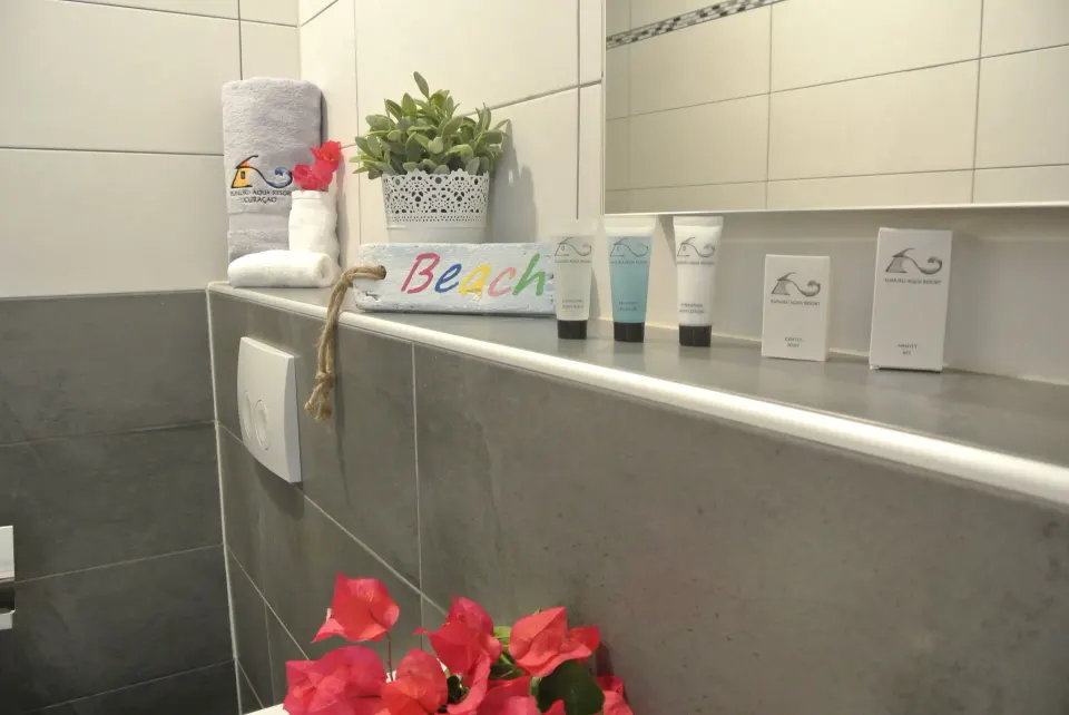 Standard Room bathroom shelf with towels and bath amenities at Kunuku Resort Curacao.