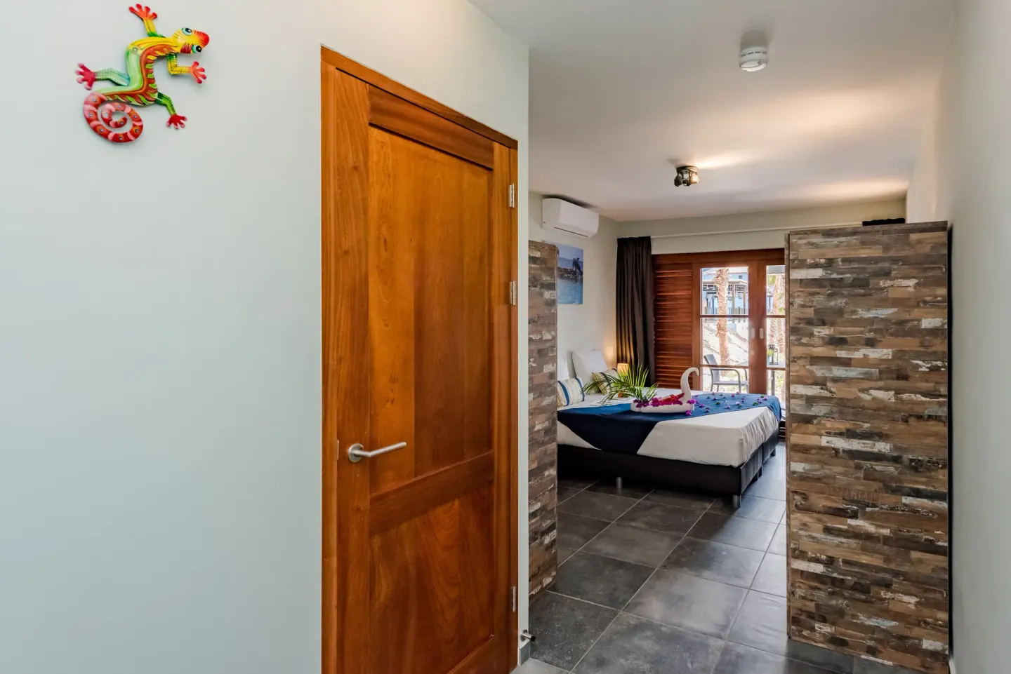 Standard Room entrance and bed with towel décor at Kunuku Resort Curacao.