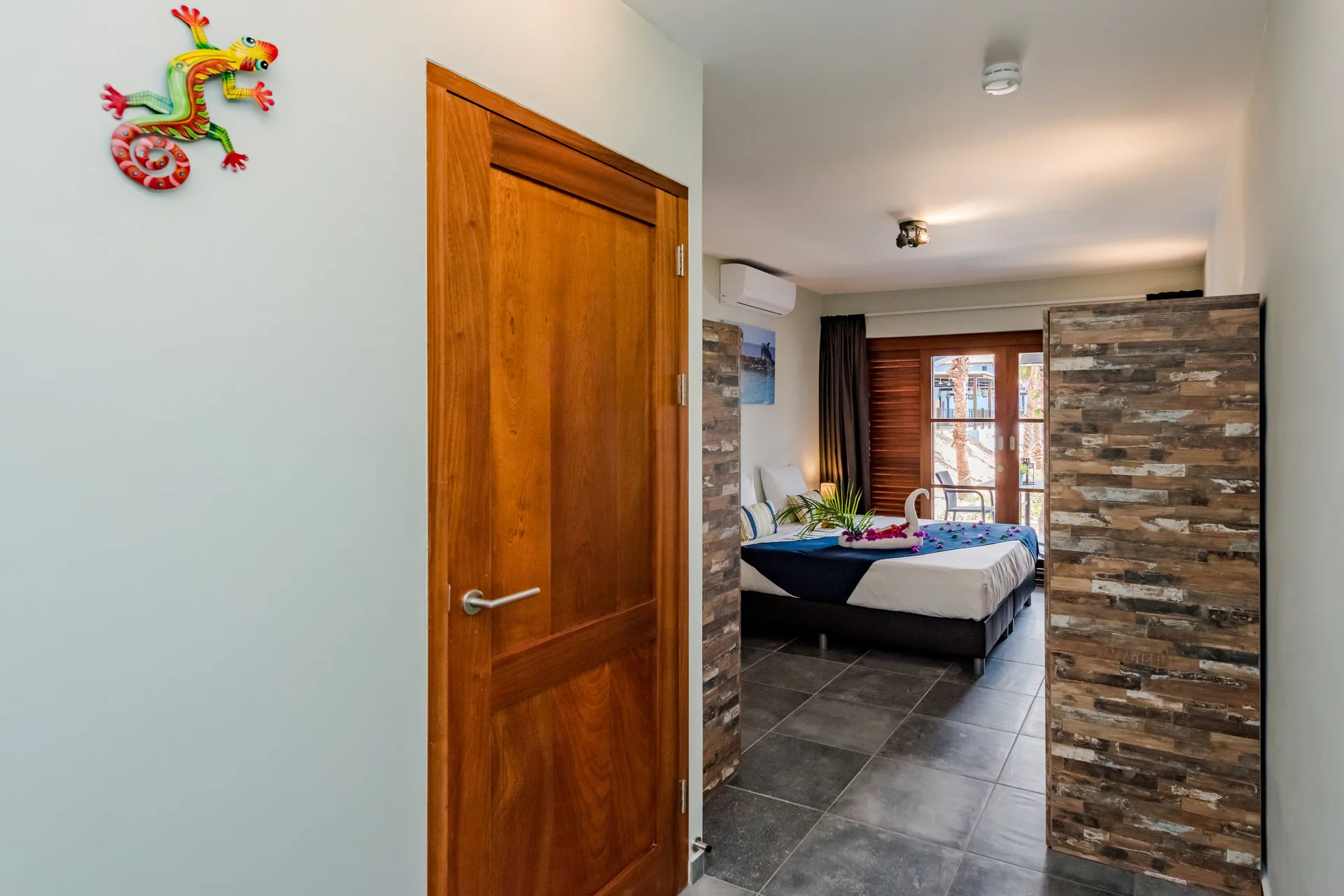 Standard Room entrance and bed with towel décor at Kunuku Resort Curacao.