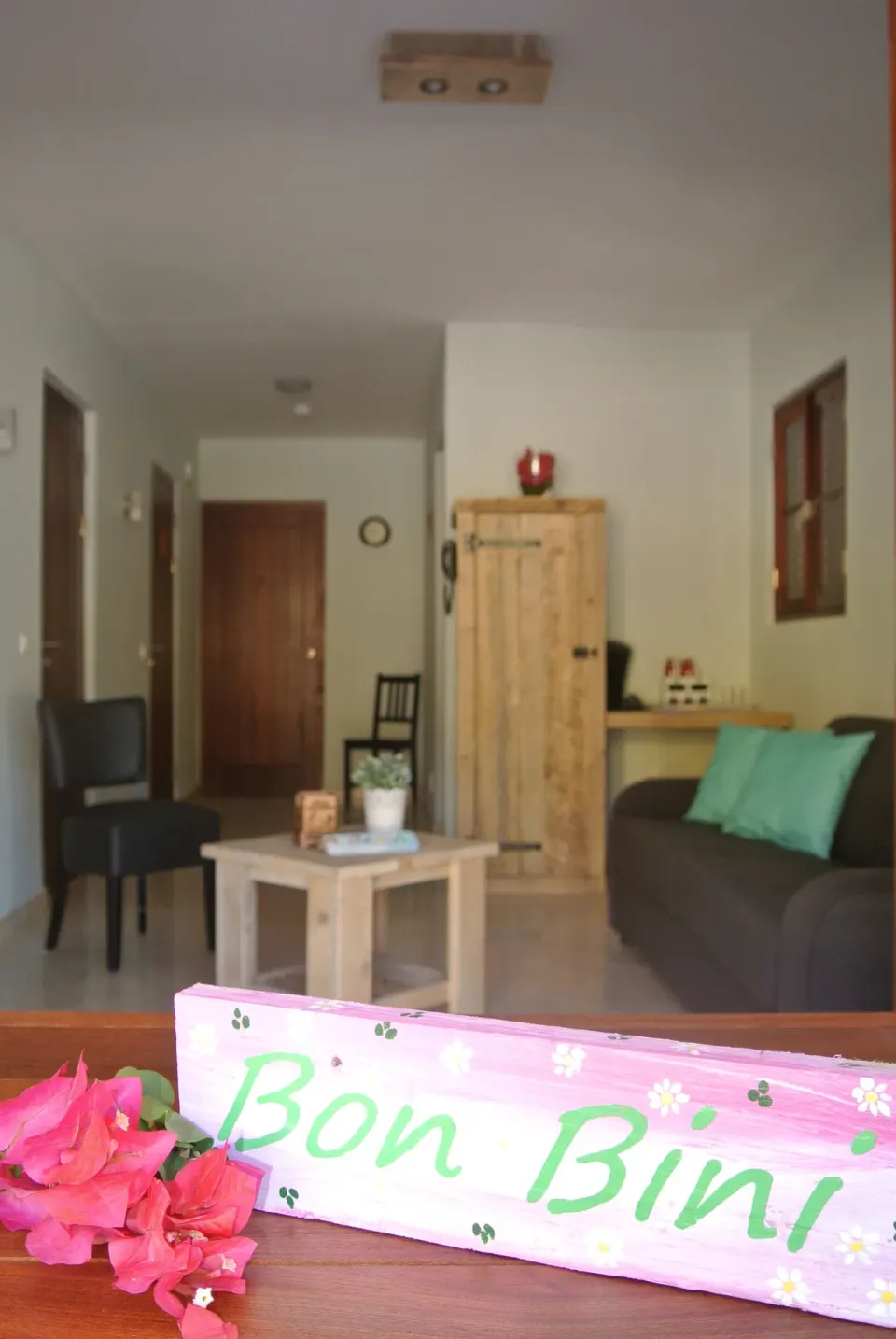 Suite living room seen past a Bon Bini sign and flowers at Kunuku Resort Curacao.