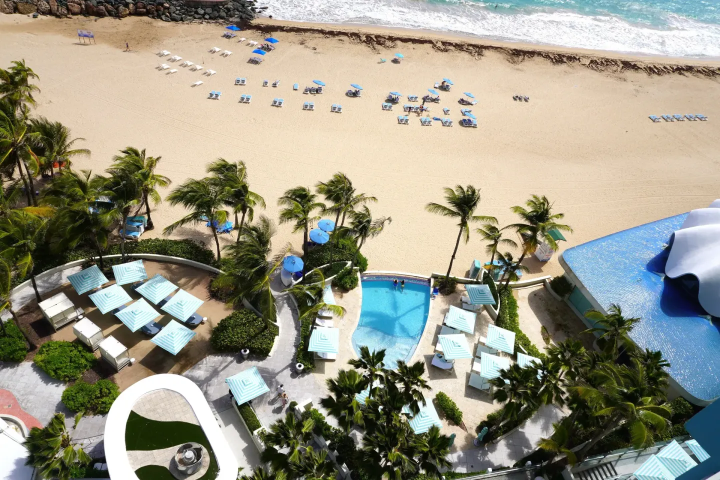 Aerial view of pools, palms, cabanas, beach, and surf at La Concha Resort, Puerto Rico.