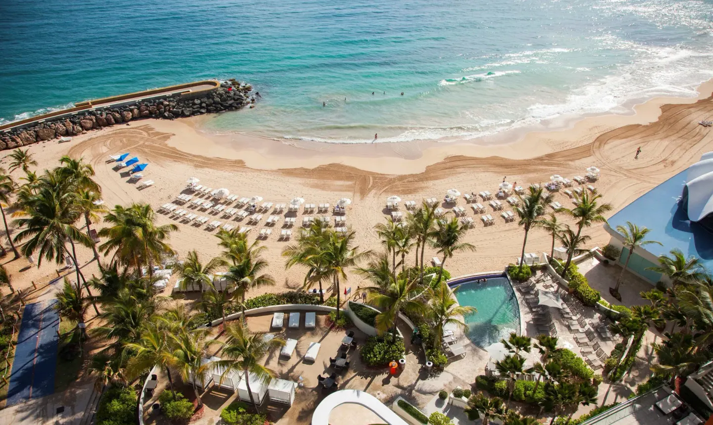 Aerial view of beach, pool, palms, and shoreline at La Concha Resort, Puerto Rico.