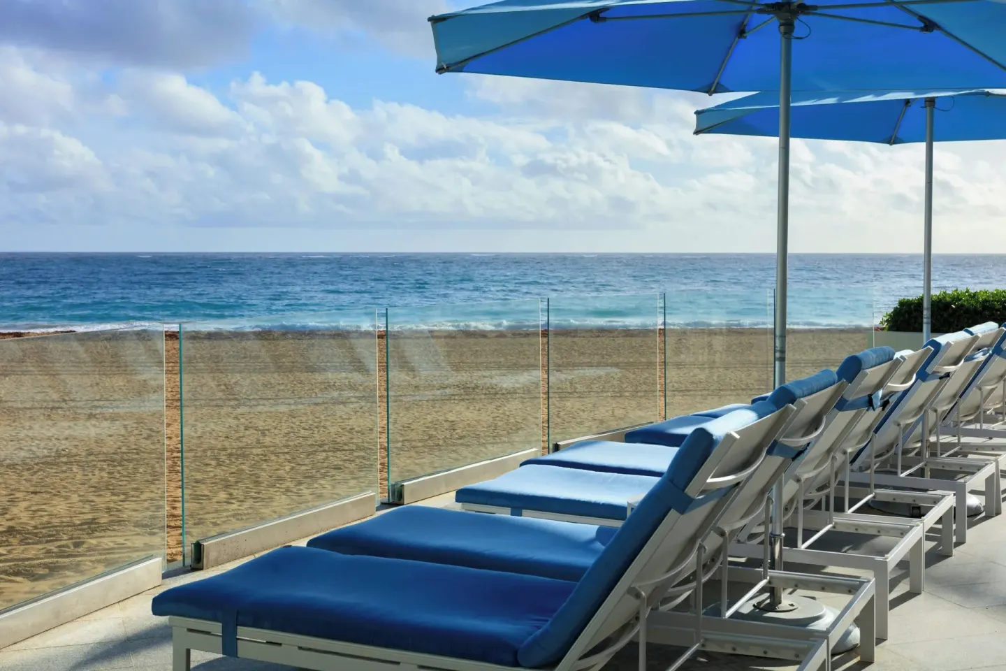 Blue cushioned loungers face the beach and ocean at La Concha Resort, Puerto Rico.