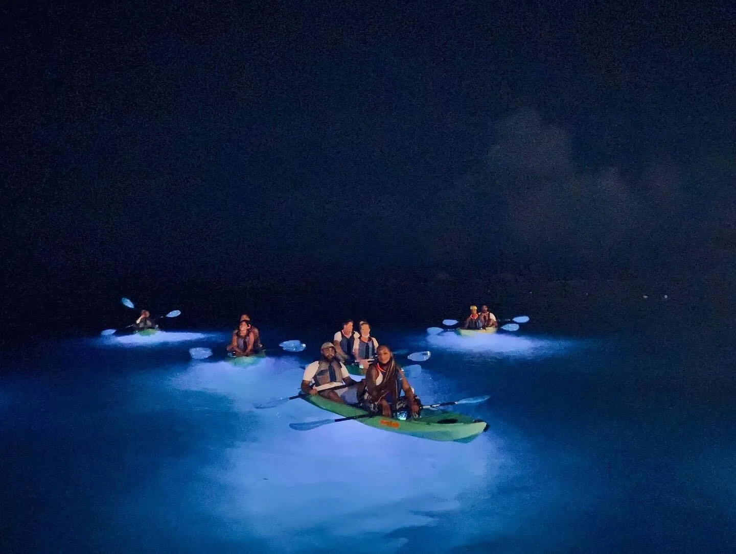 Guests paddle illuminated kayaks on dark water during a nighttime outing at La Concha Resort, Puerto Rico.
