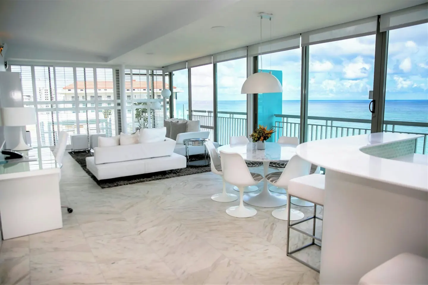 Ocean-view suite with white sofa, dining table, balcony, and kitchenette at La Concha Resort, Puerto Rico.