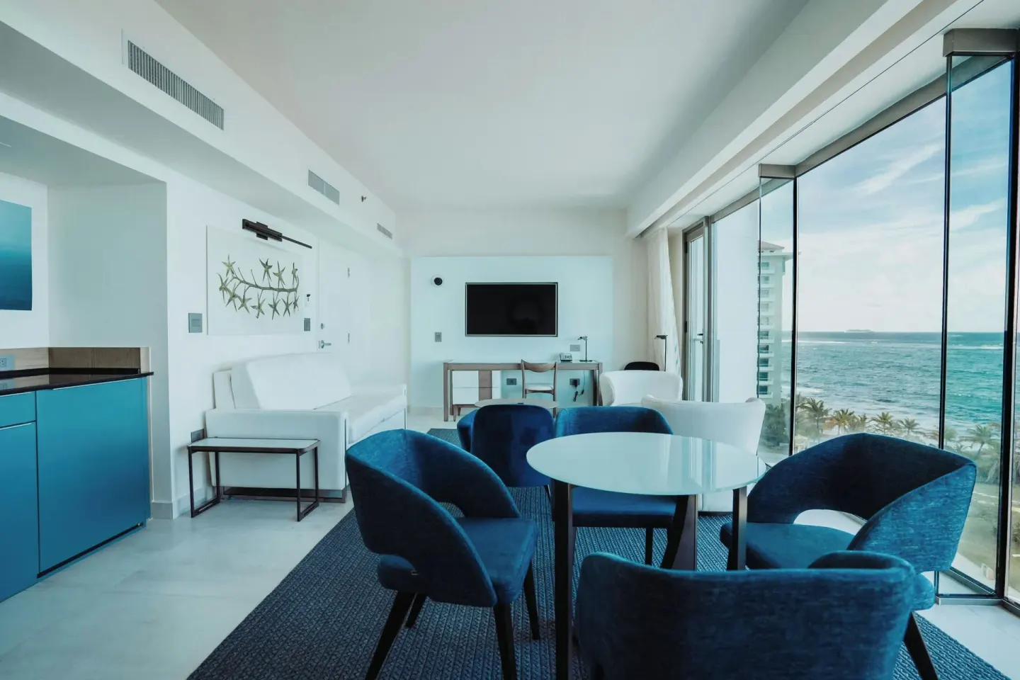 Suite living area with kitchenette, dining table, and ocean windows at La Concha Resort, Puerto Rico.