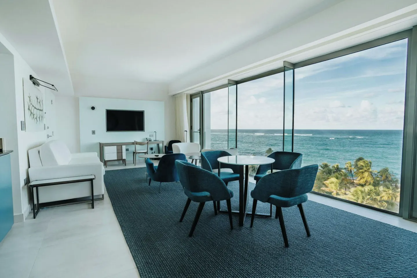 Ocean-view suite living area with blue chairs and sofa at La Concha Resort, Puerto Rico.