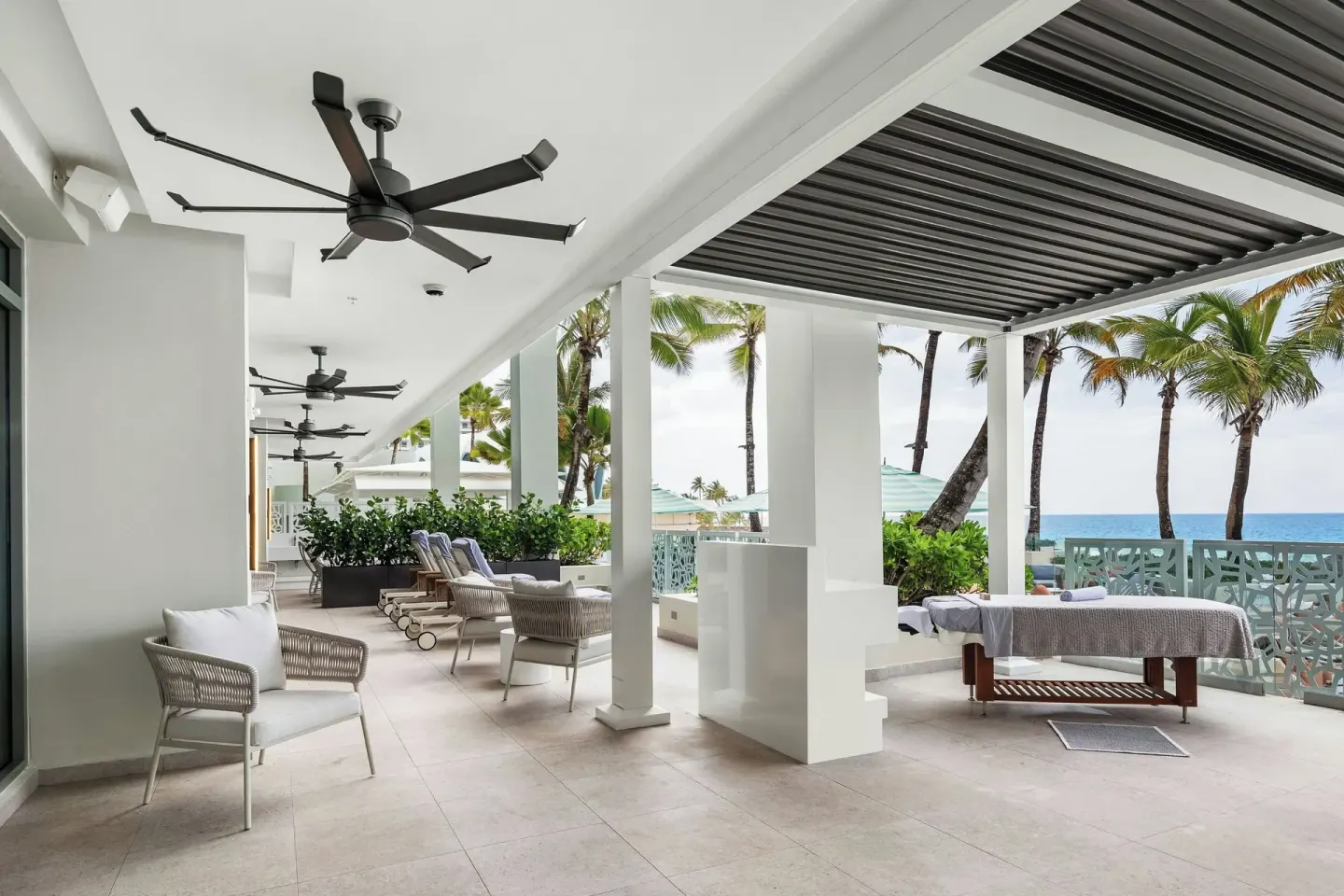 Shaded spa terrace with lounge chairs and ocean beyond at La Concha Resort, Puerto Rico.