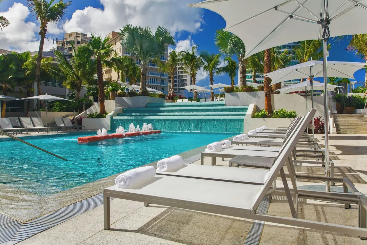 Pool with fountains, loungers, and umbrellas at La Concha Resort, Puerto Rico.