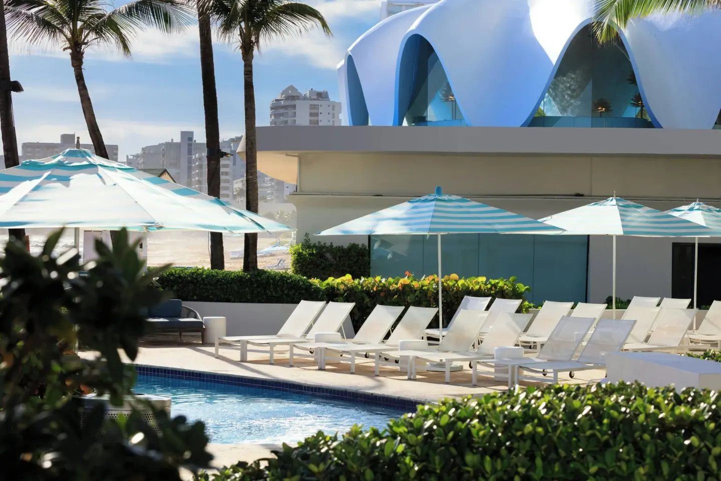 Poolside loungers and striped umbrellas at La Concha Resort, Puerto Rico.