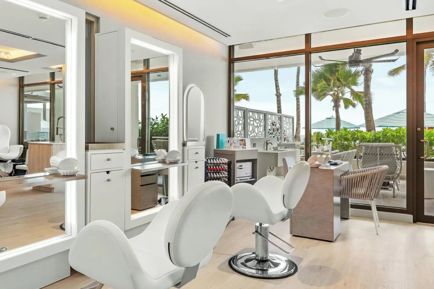 Salon chairs and mirrored stations near palm-view windows at La Concha Resort, Puerto Rico.