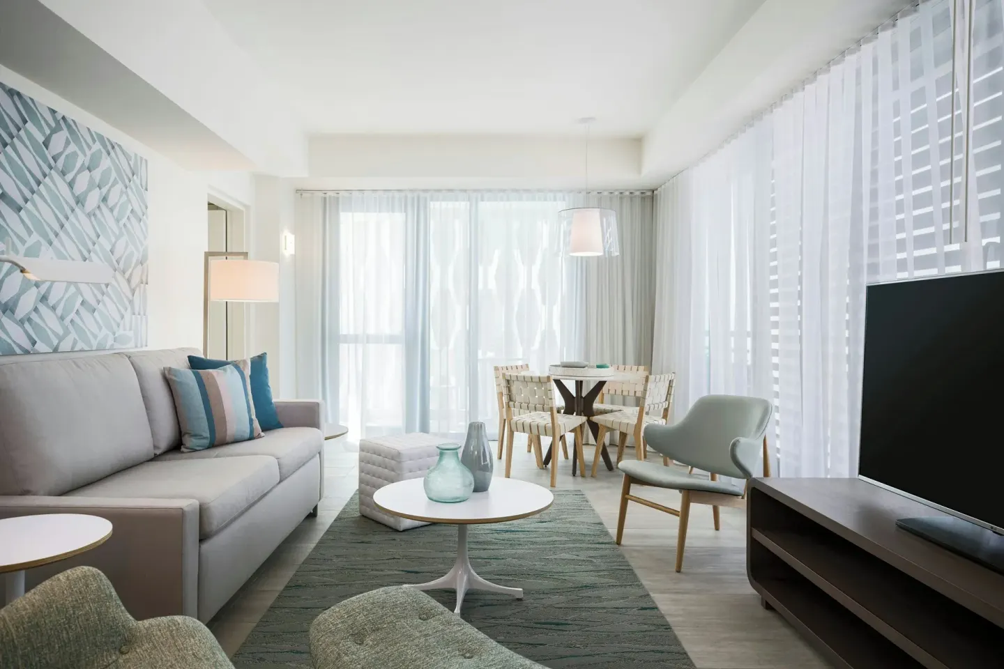 Bright suite living room with sofa, TV, and dining nook at La Concha Resort, Puerto Rico.