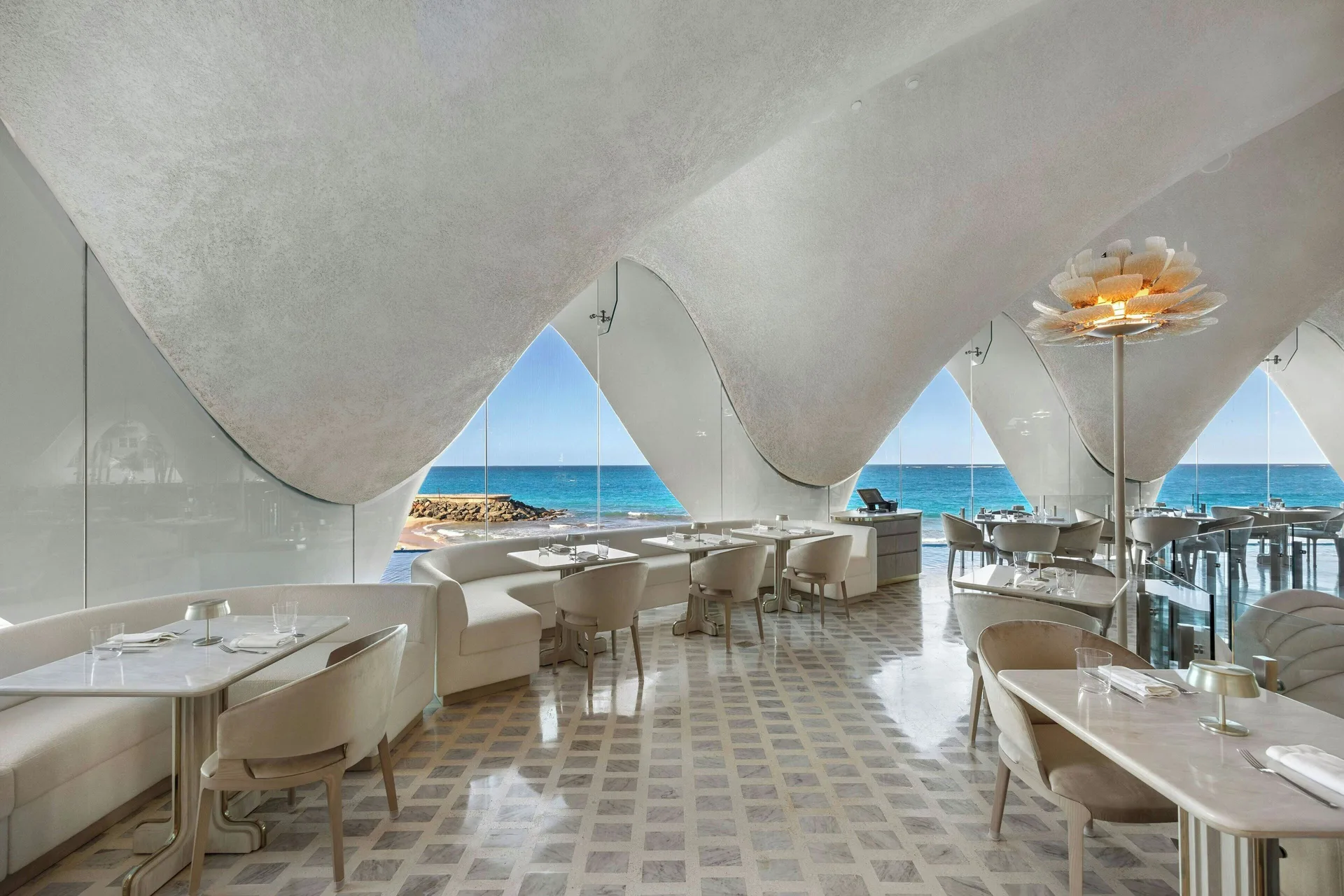 Bright oceanfront dining room with arched glass openings at La Concha Resort, Puerto Rico.