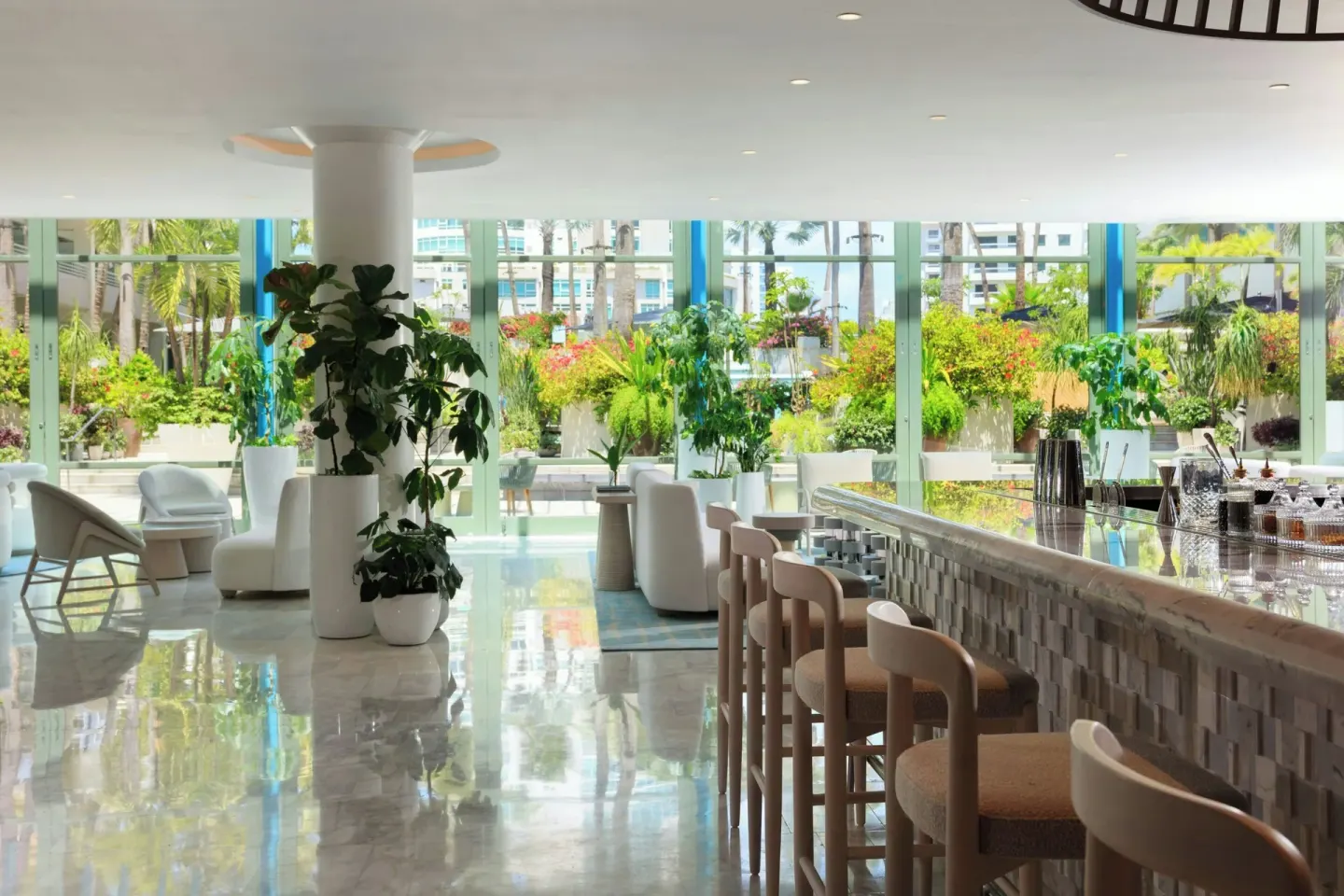 Lobby bar with stools and garden-facing windows at La Concha Resort, Puerto Rico.