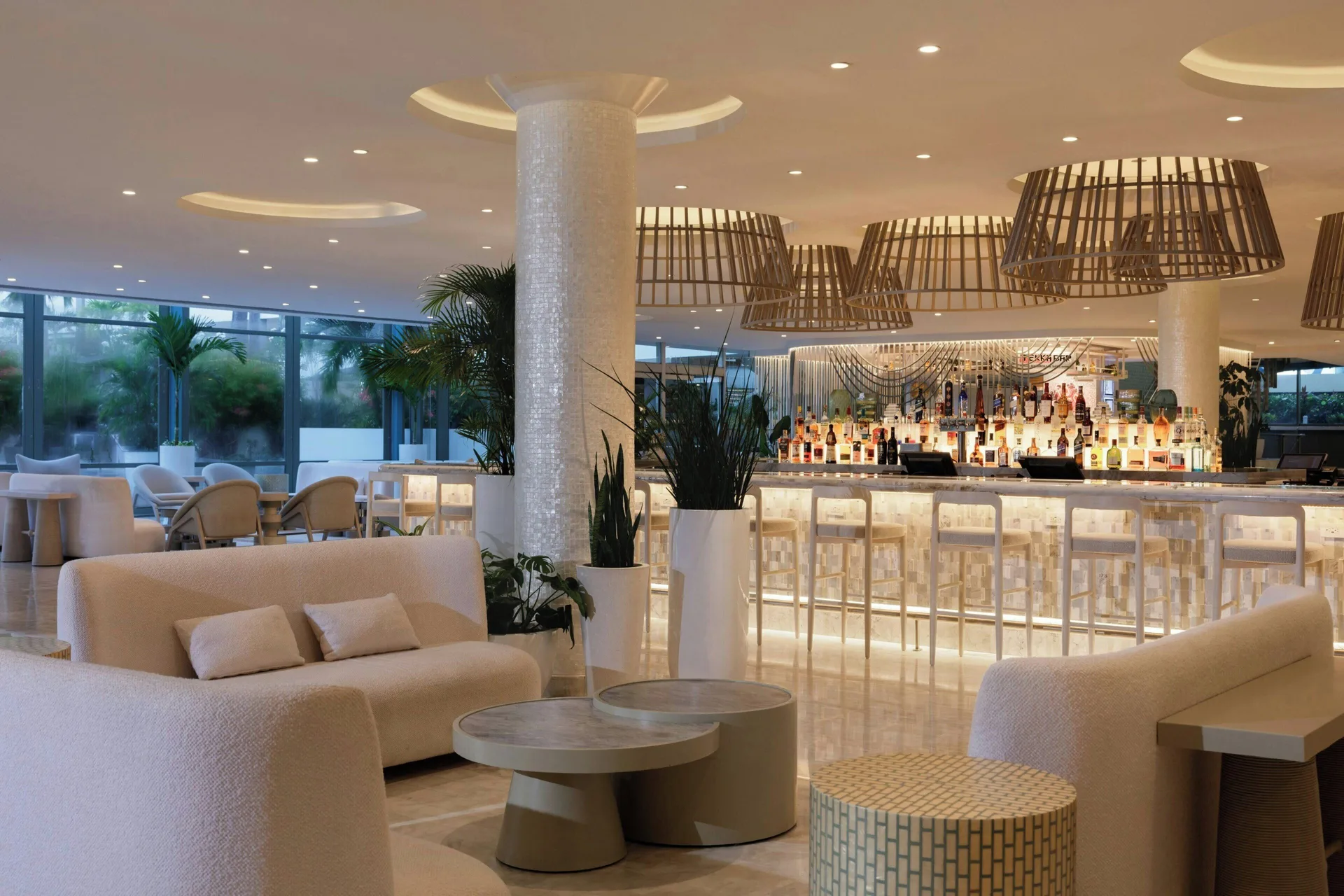 A white lounge bar with sofas and illuminated bottles at La Concha Resort, Puerto Rico.