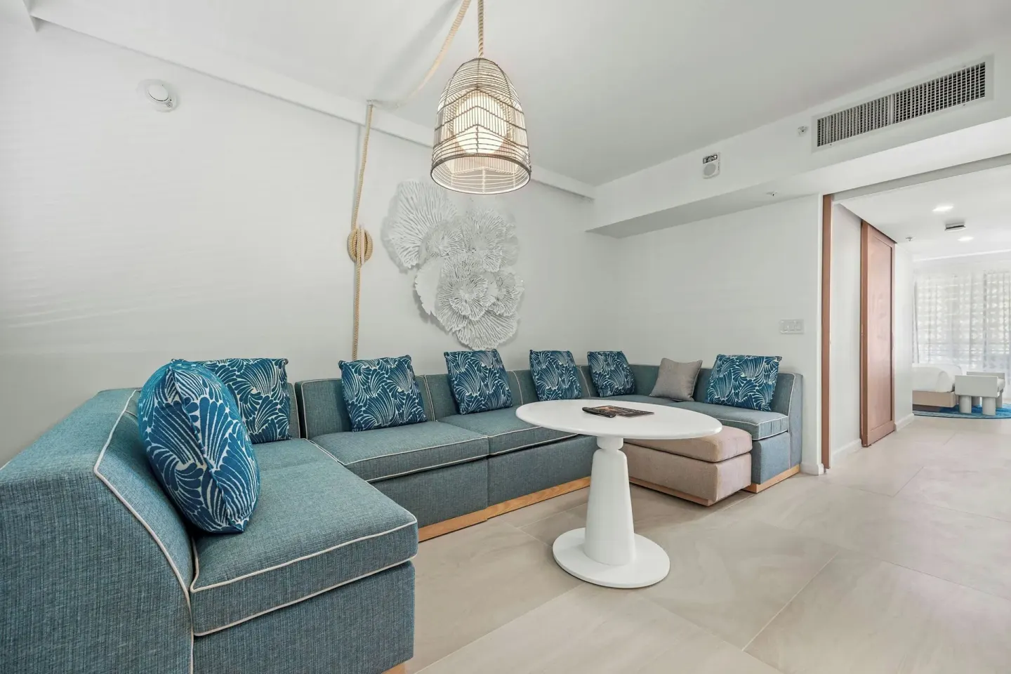 Deluxe Suite lounge area with blue sectional and round table at La Concha Resort, Puerto Rico.