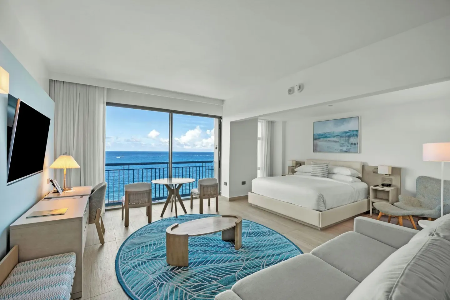 Ocean-view junior suite with king bed, sofa bed, desk, and balcony seating at La Concha Resort, Puerto Rico.