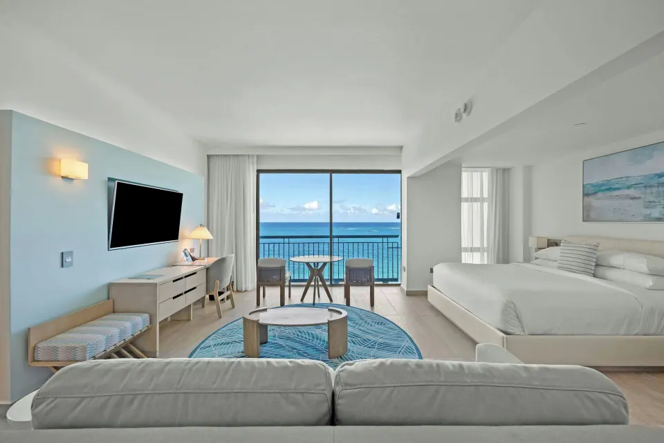 Junior suite with sofa bed, king bed, desk, TV, and ocean balcony at La Concha Resort, Puerto Rico.