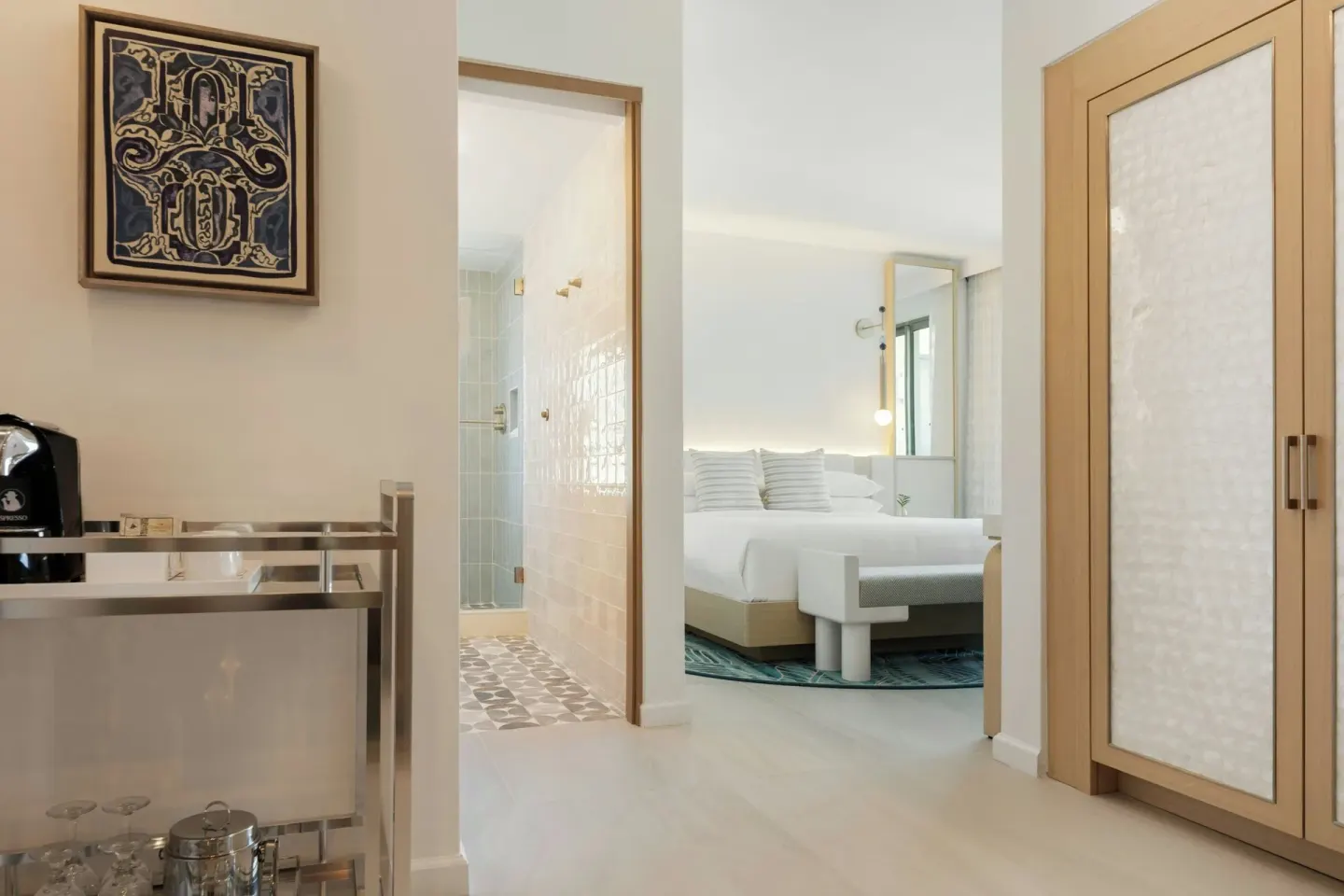 Entry area with minibar cart, wardrobe, bathroom doorway, and bed at La Concha Resort, Puerto Rico.