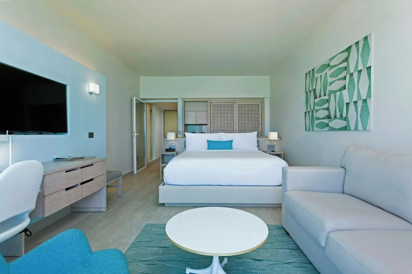 Spacious guest room with king bed, sofa, desk, and TV at La Concha Resort, Puerto Rico.