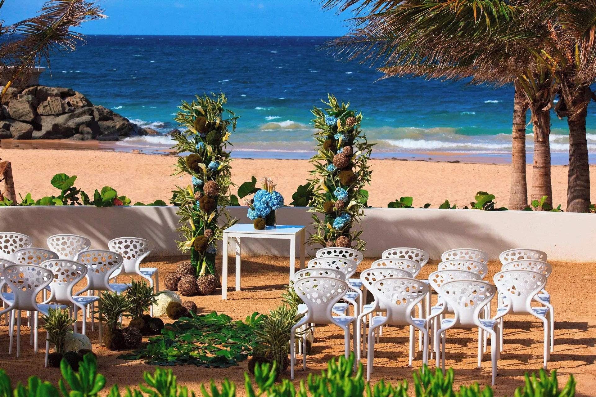 Beachfront wedding ceremony chairs and floral arch at La Concha Resort, Puerto Rico.