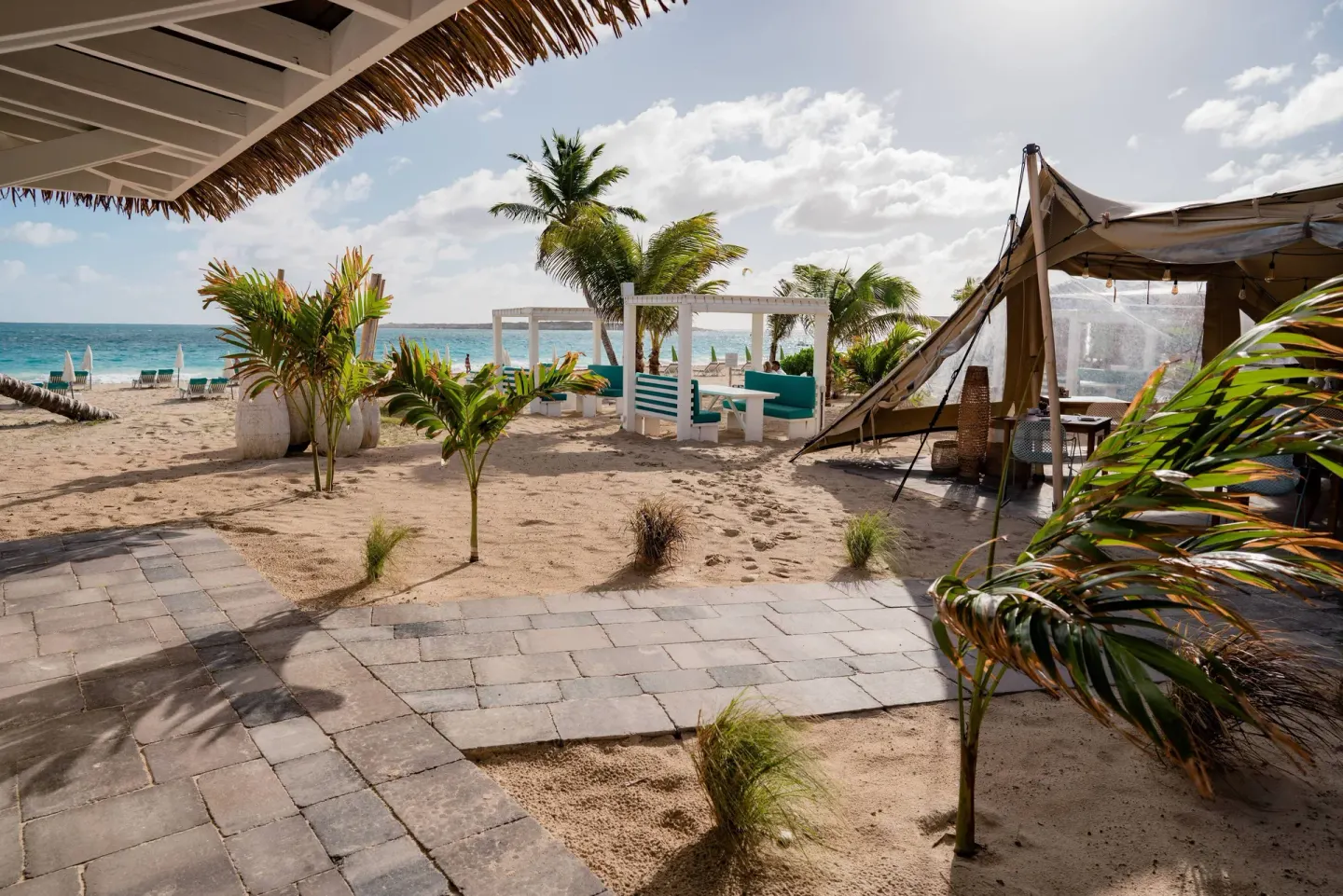Sandy garden path, palms, cabana seating, and beach at La Playa Orient Bay.