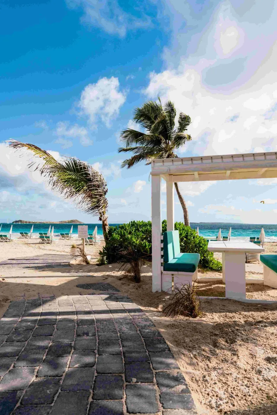 Palm-lined beach path beside a cabana at La Playa Orient Bay.