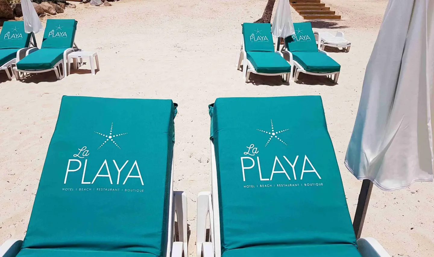Close view of turquoise beach loungers and umbrellas at La Playa Orient Bay.