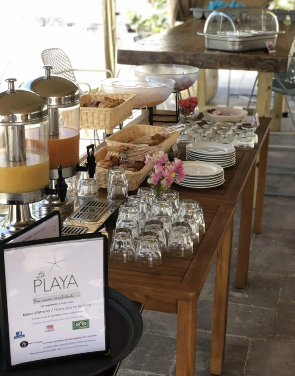 Breakfast buffet with juices, pastries, plates, and glasses at La Playa Orient Bay.