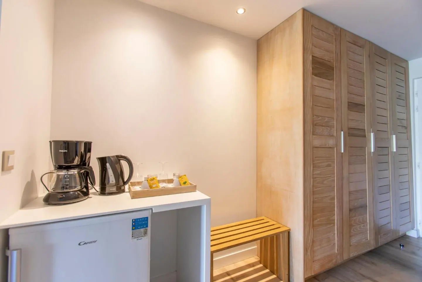 Classic Junior Suite refreshment area at La Playa Orient Bay with mini fridge, kettle and wood wardrobes.