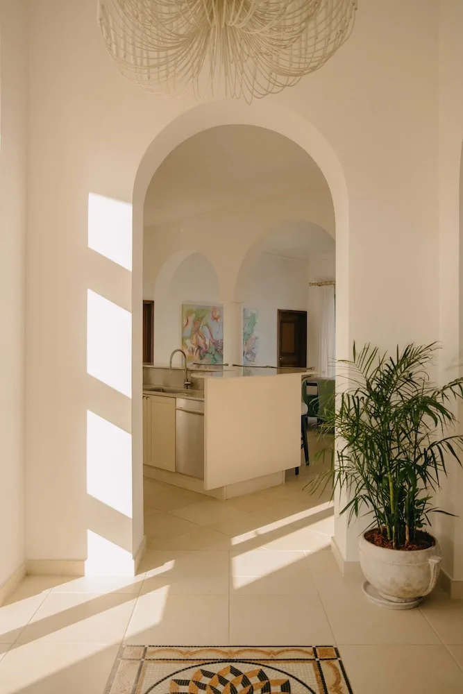 Arched interior entry with potted palm and kitchen beyond at La Samanna, St Martin.