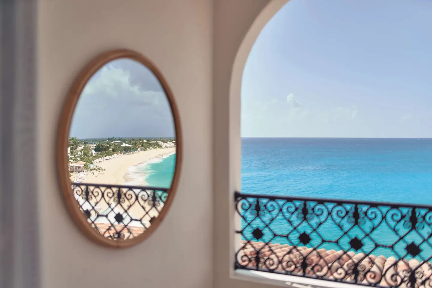 Balcony arch and round mirror reflecting the beach at La Samanna, St Martin.