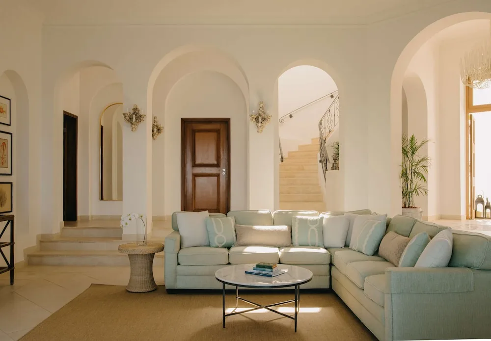Living room with pale sectional sofa and arched doorways at La Samanna, St Martin.