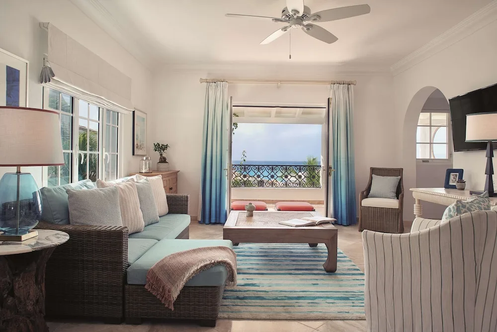 Ocean-view suite sitting area with wicker sofa and balcony at La Samanna, St Martin.