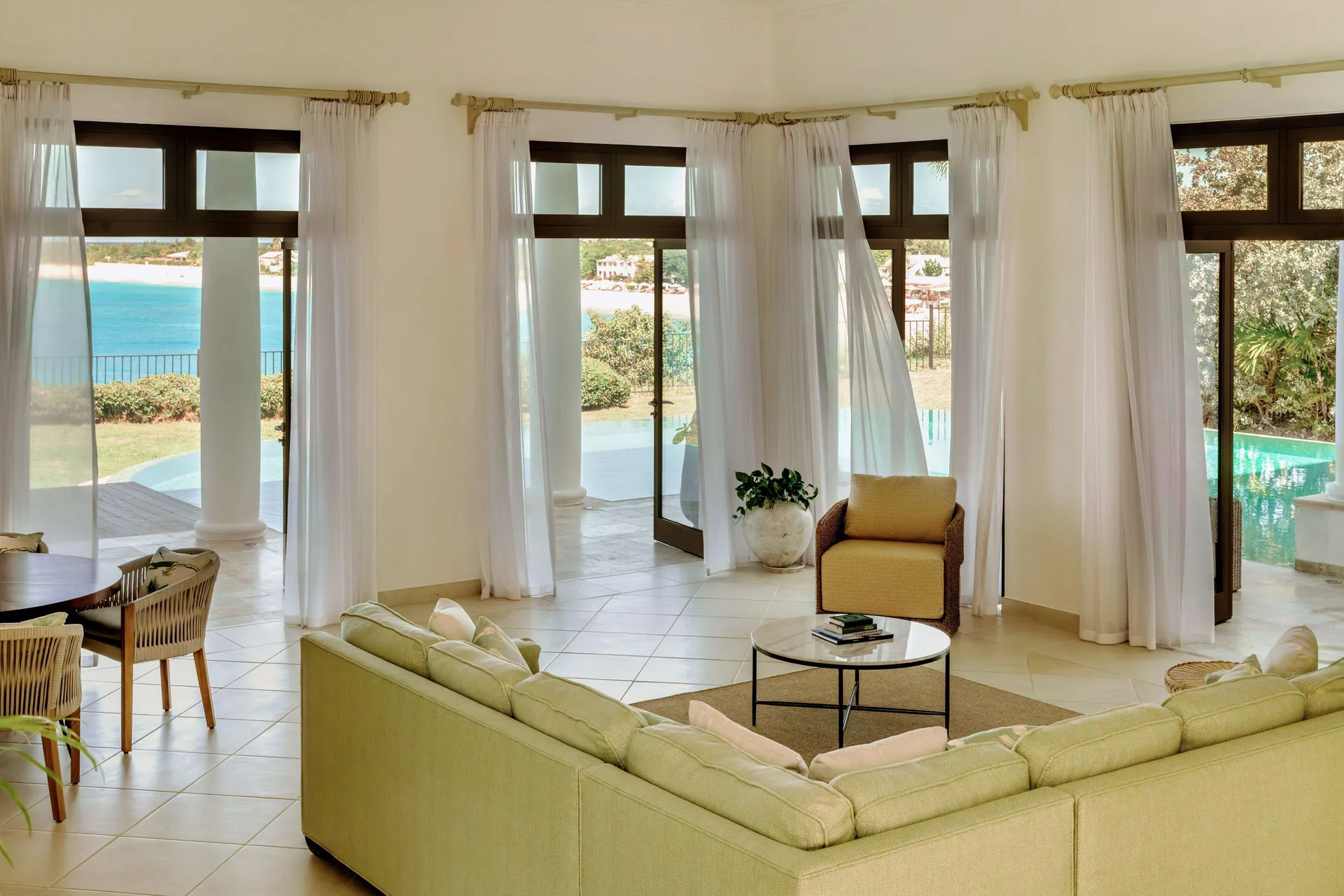 Living room with sofas, tall windows and sea views at La Samanna, St Martin.