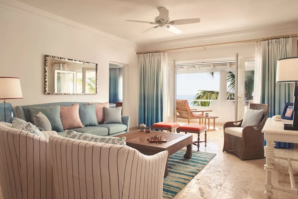 Suite living room with sofas opening to an ocean-view terrace at La Samanna, St Martin.
